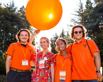 Reunion assistants smiling with a large orange balloon