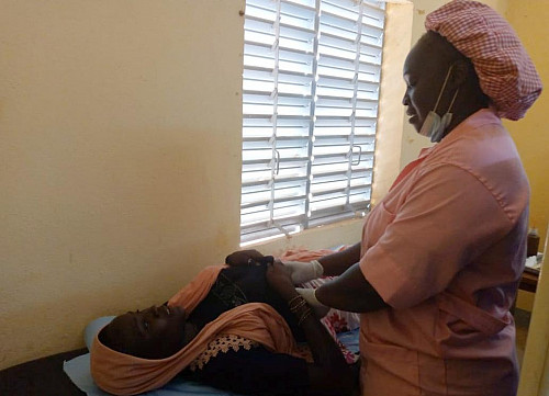 Midwife conducting breast screening.