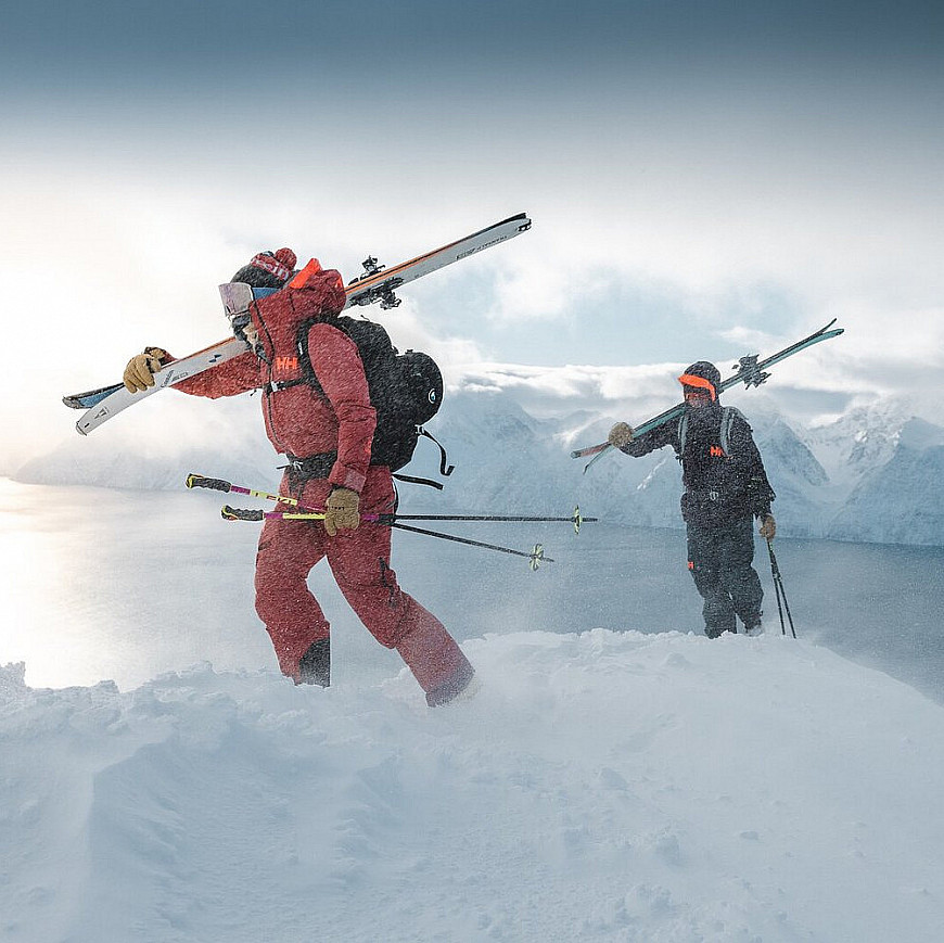 Two skiers walk across a snowy landscape