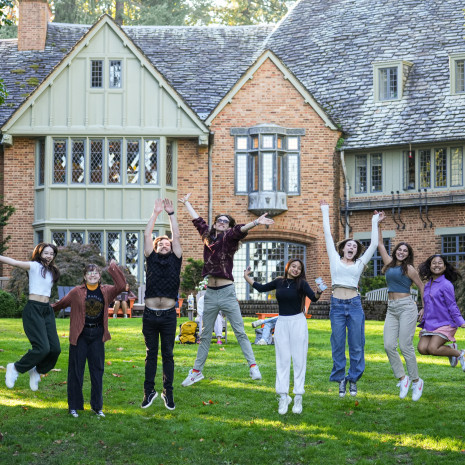 Students jumping in front of the Manor House.