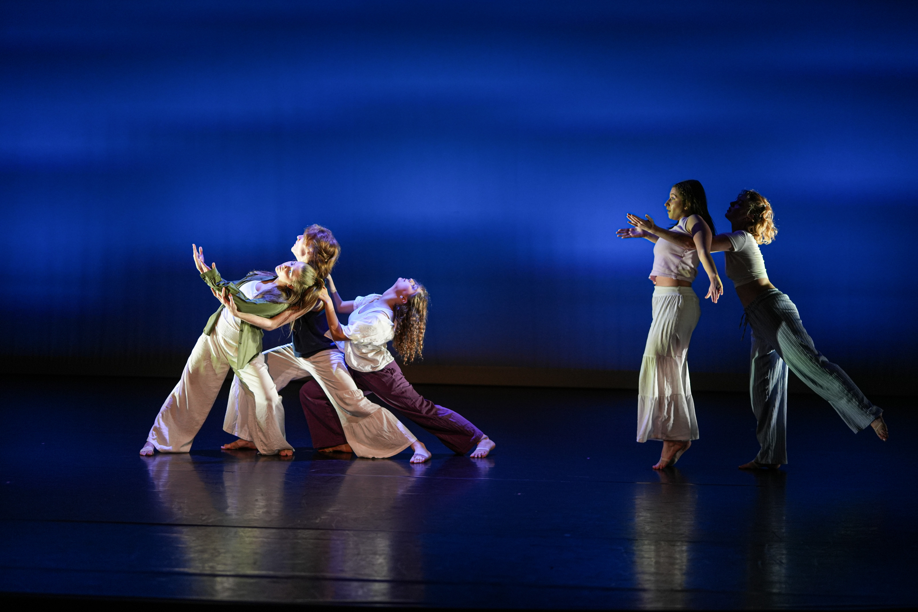 Two groups of students dancing against a blue background.