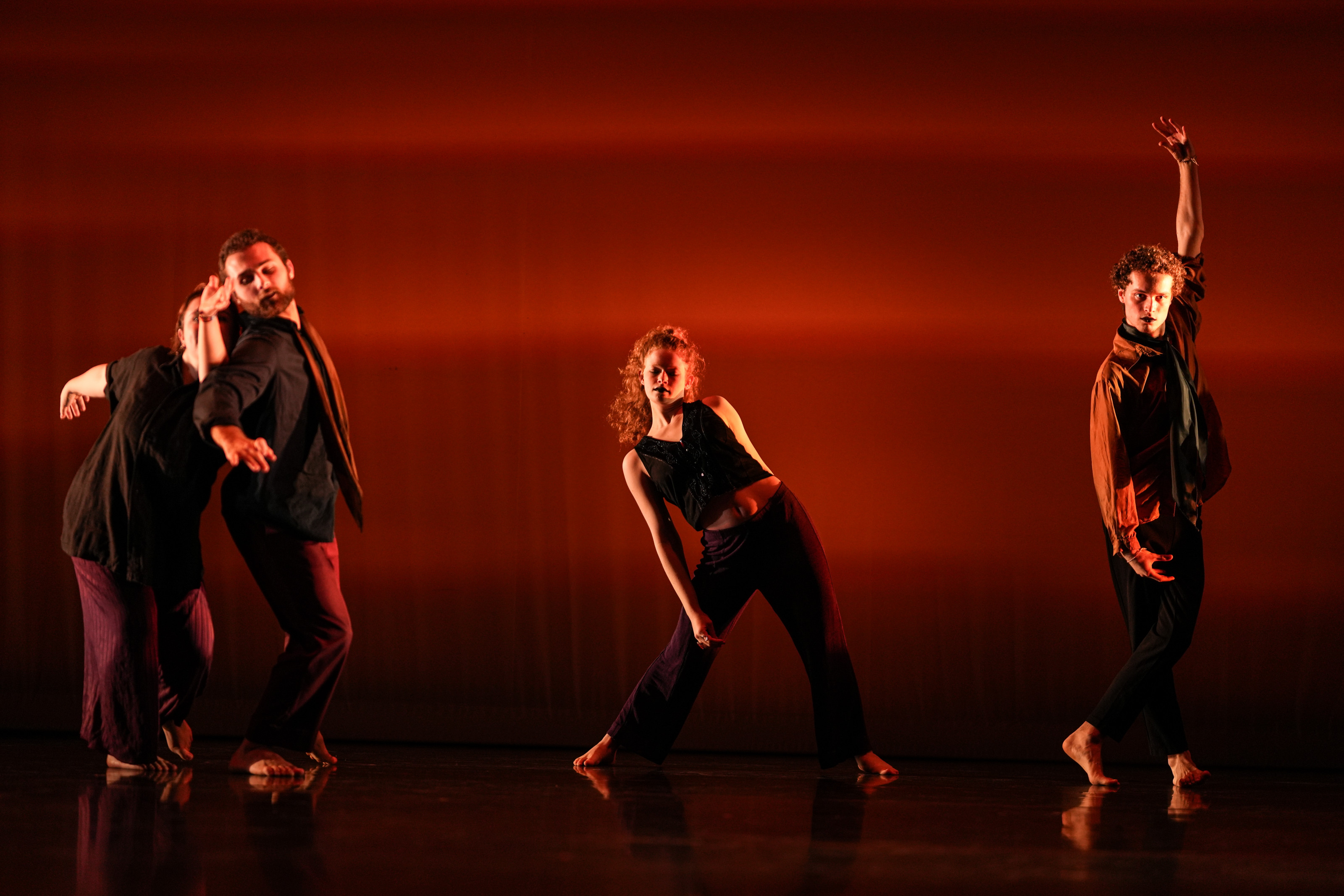 Students posing/dancing against a red background.