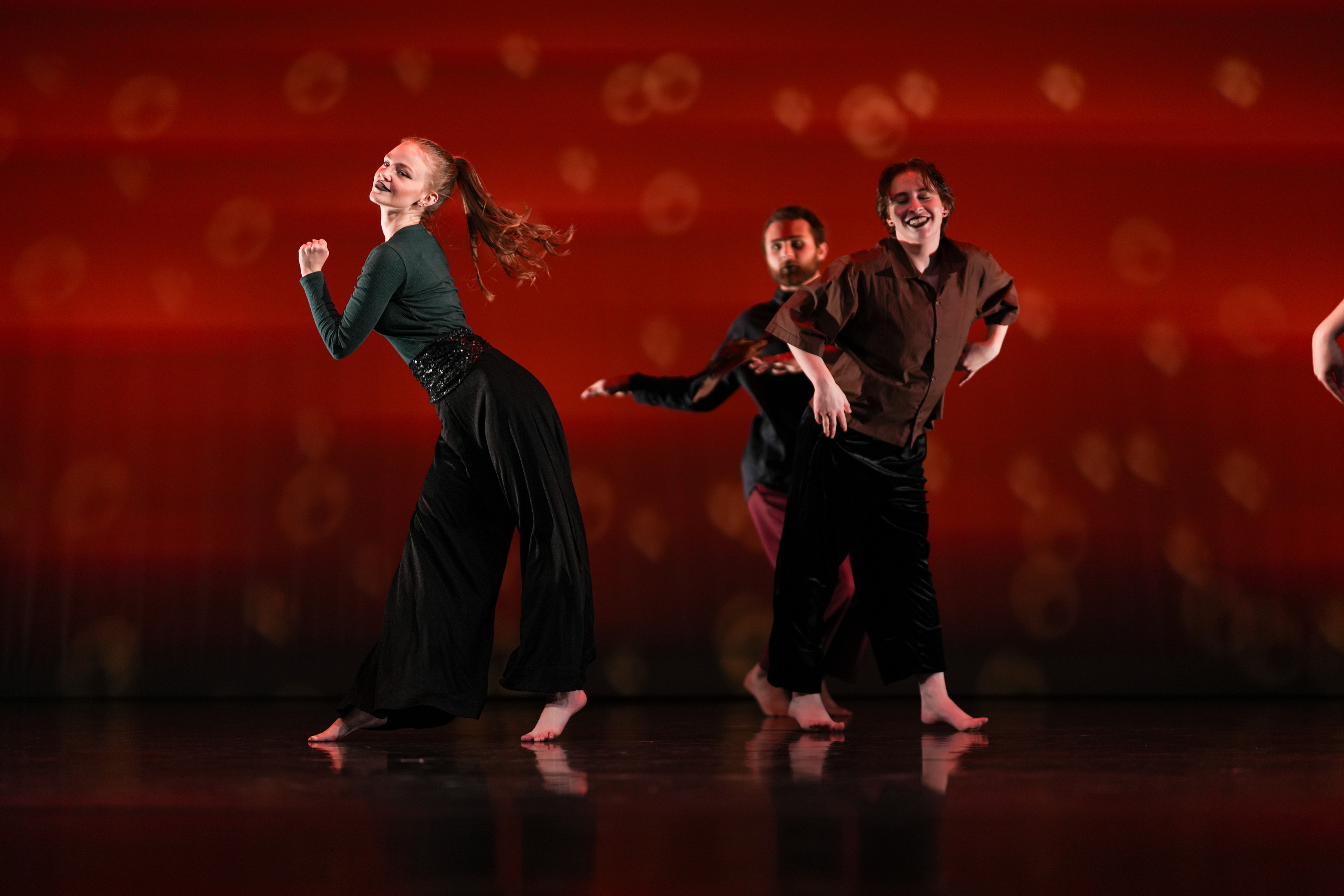 Students dancing against a red background.