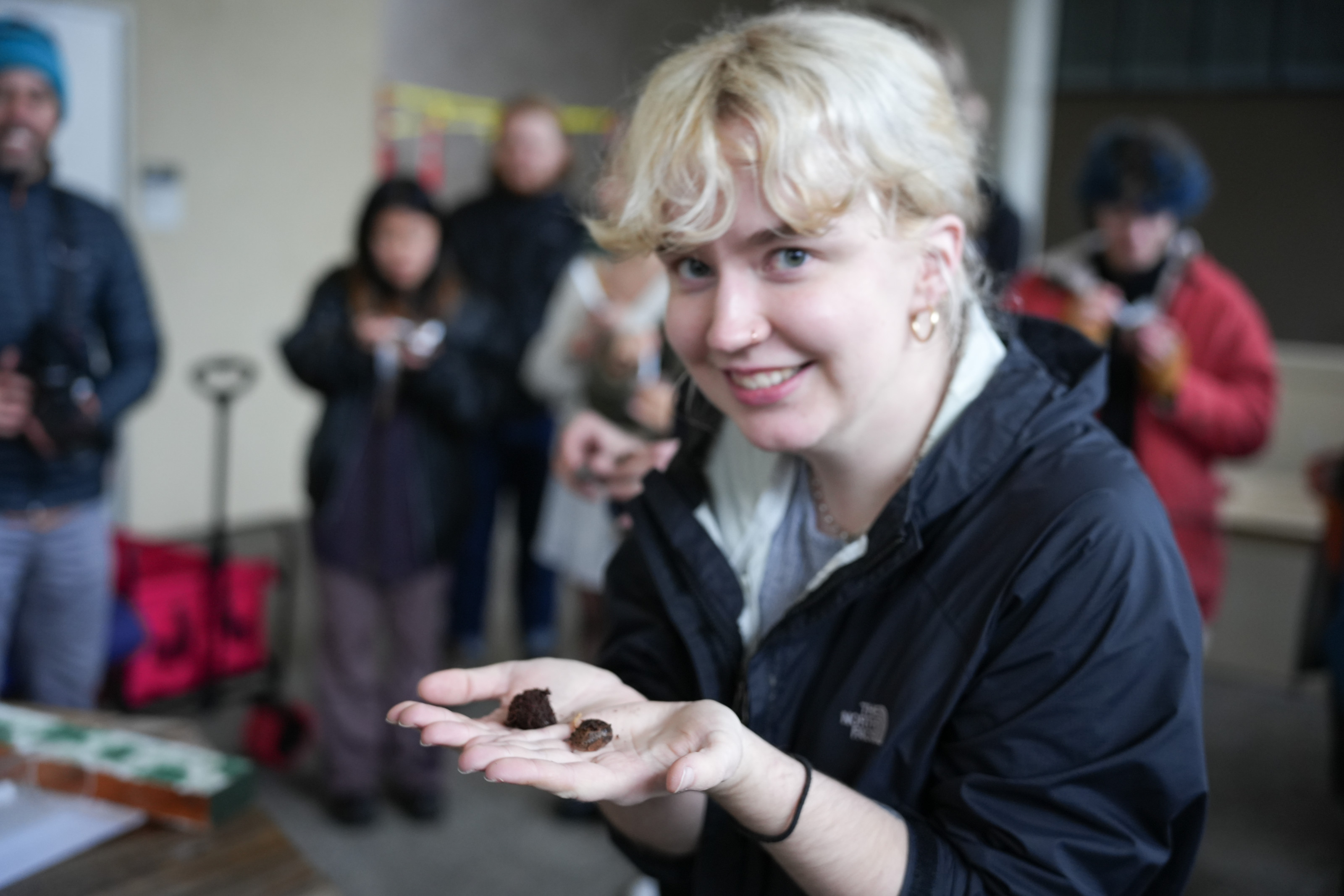 A student smiles as they hold a slug in their hands.