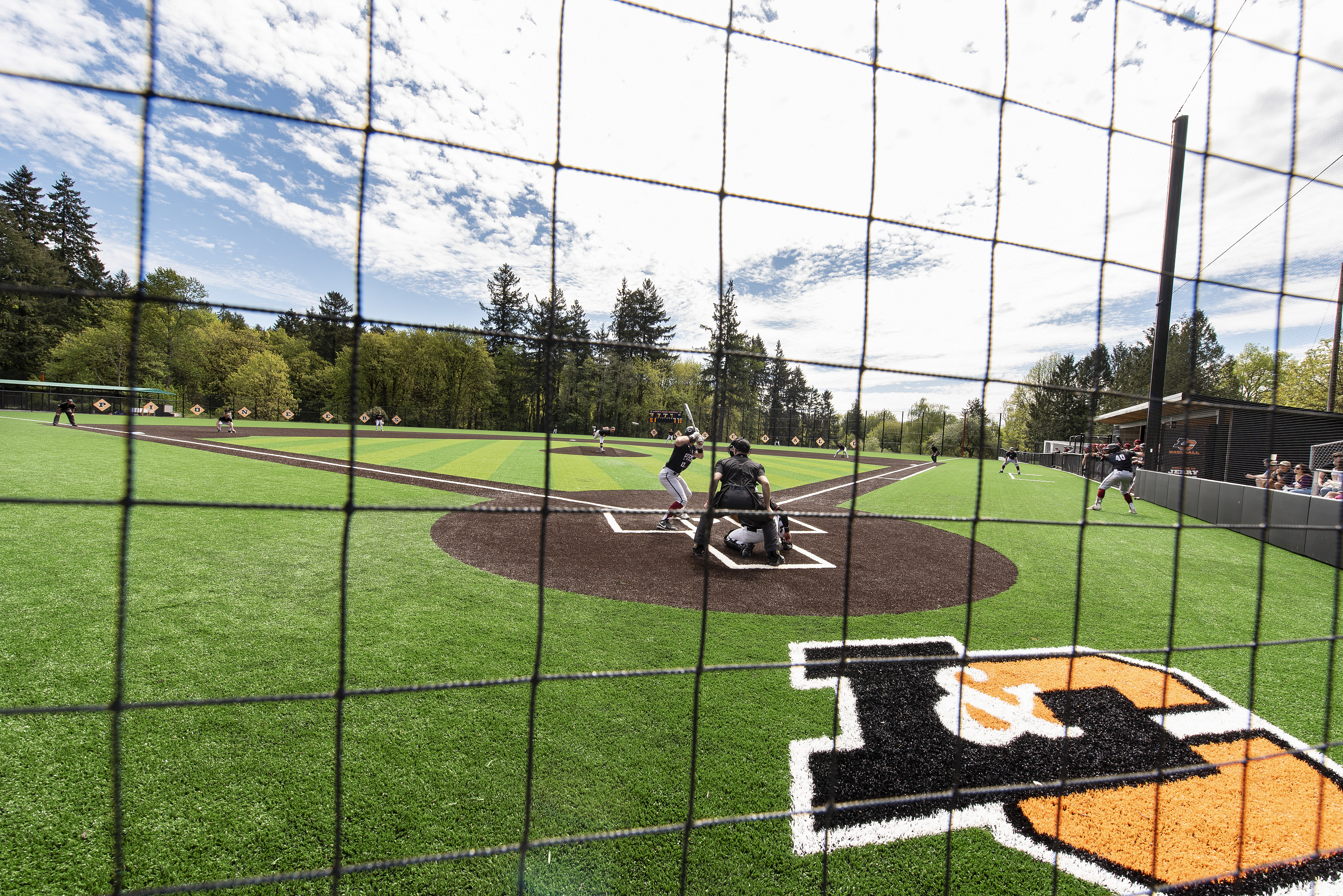 View of the baseball game from behind a net.