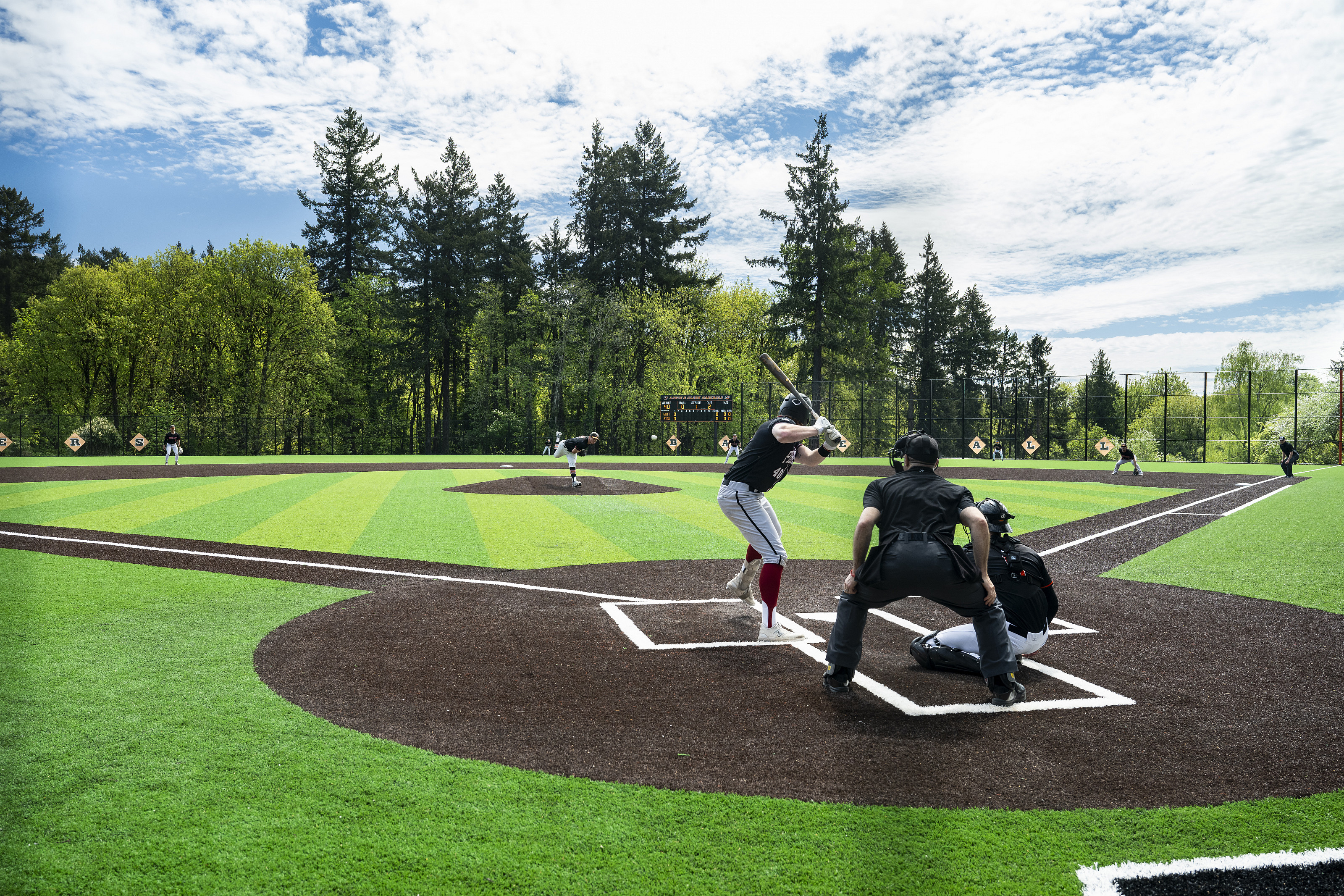 Baseball player getting ready to hit a ball, with the catcher and a referee behind him.