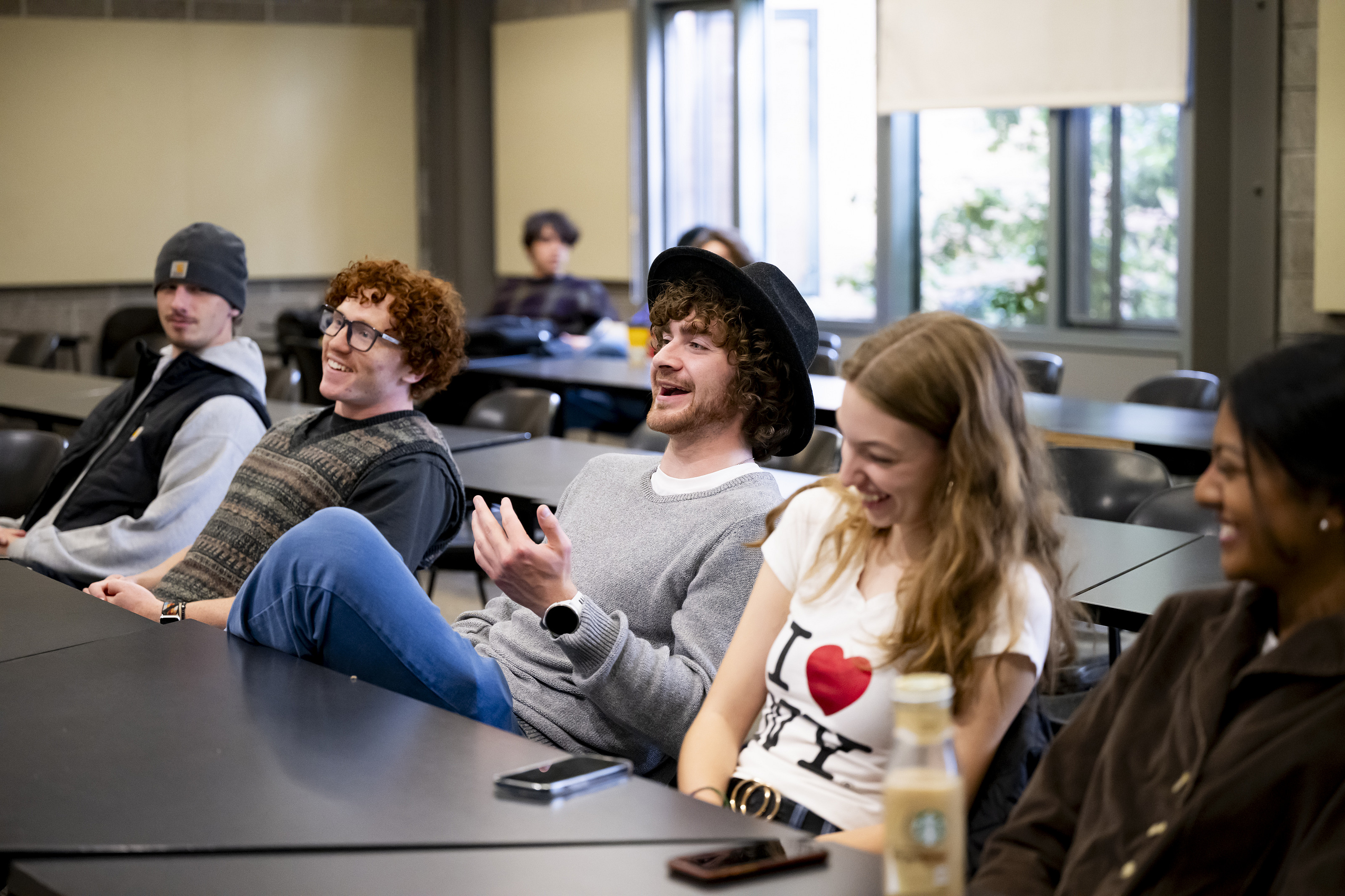 A group of students in a classroom, laughing.