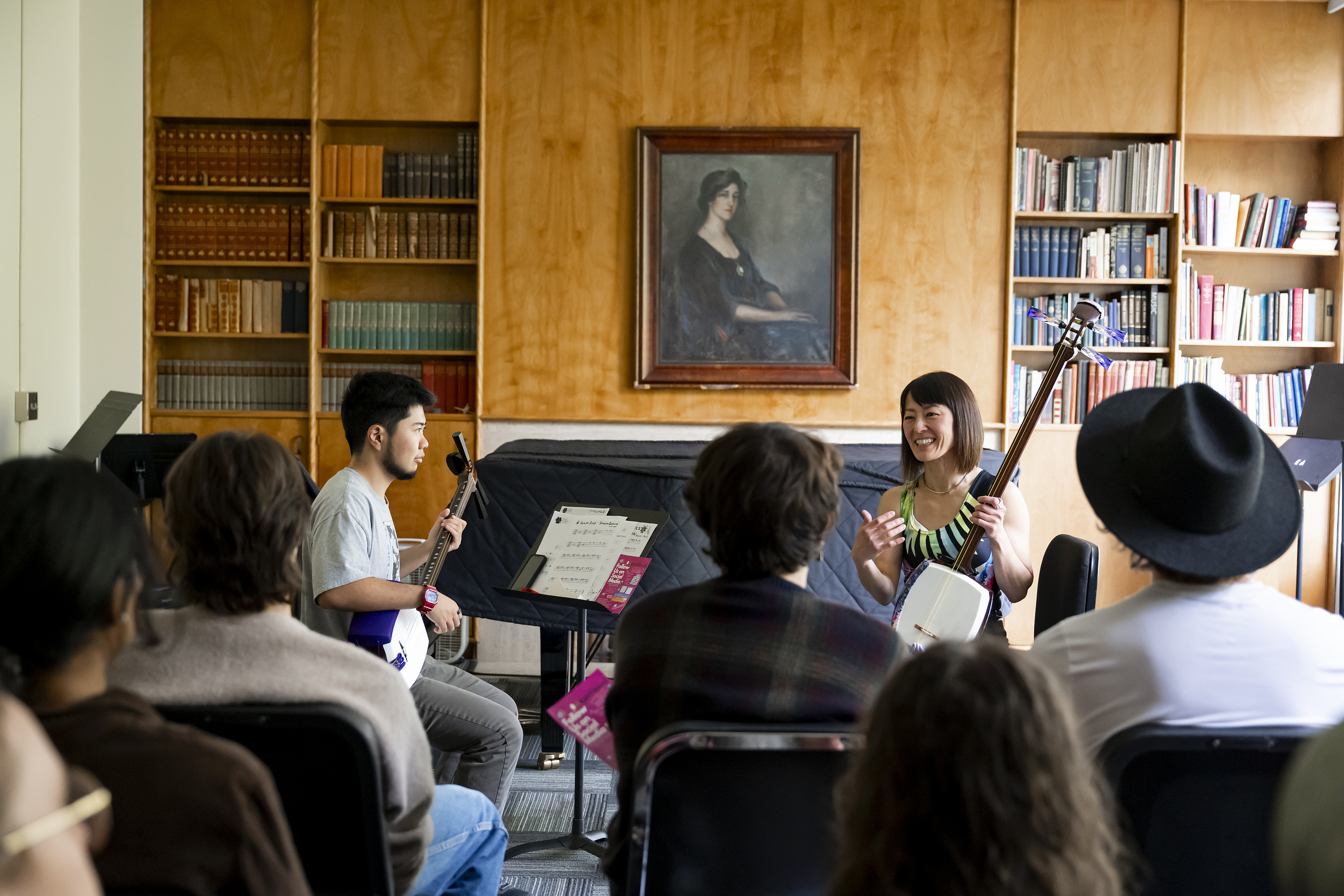 Two performers in front of a group of students in a classroom.