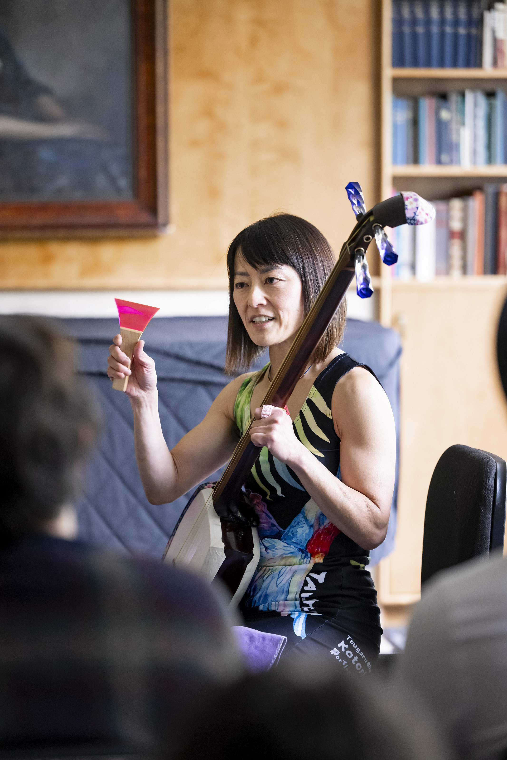 A performer holds up a Japanese instrument.