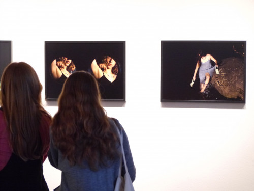 Students standing in front of a wall of art.