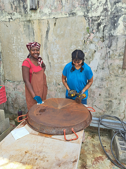Students buff out paella pans with the organization Tenedor Social. (Puerto Rico)