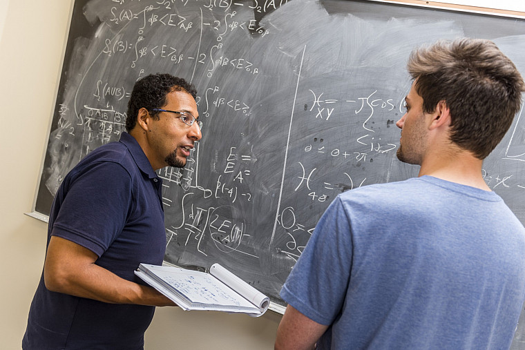 Physics professor Mohamed Anber and physics major Ben Kolligs '18 work through a theoretical physics problem together.