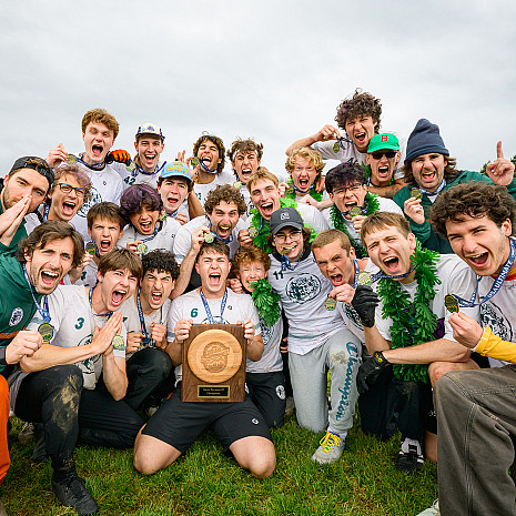 Group of students posing and cheering with their trophy.
